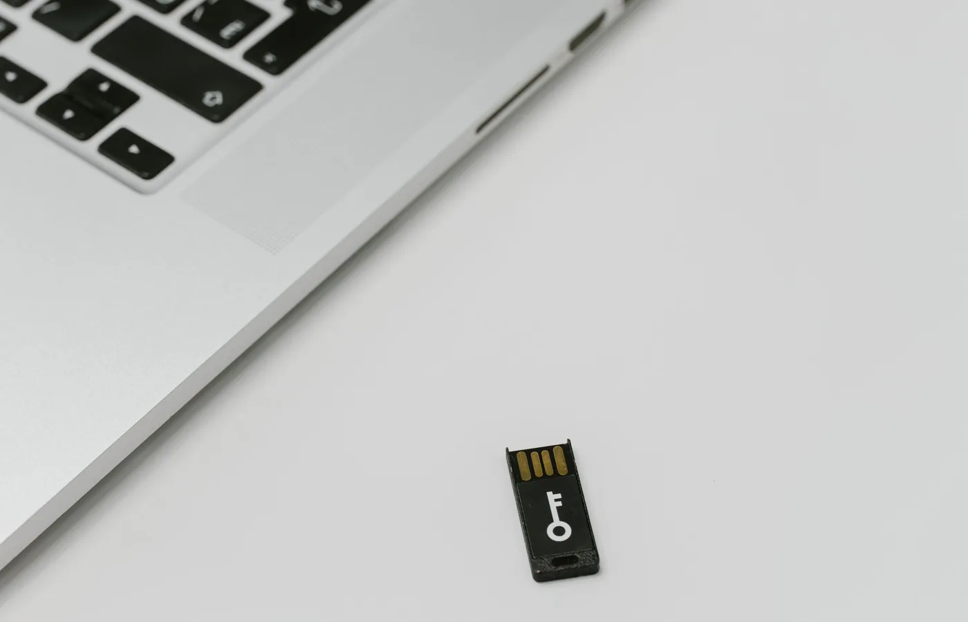 USB ключ безопасности рядом с ноутбуком как пример защищённого носителя