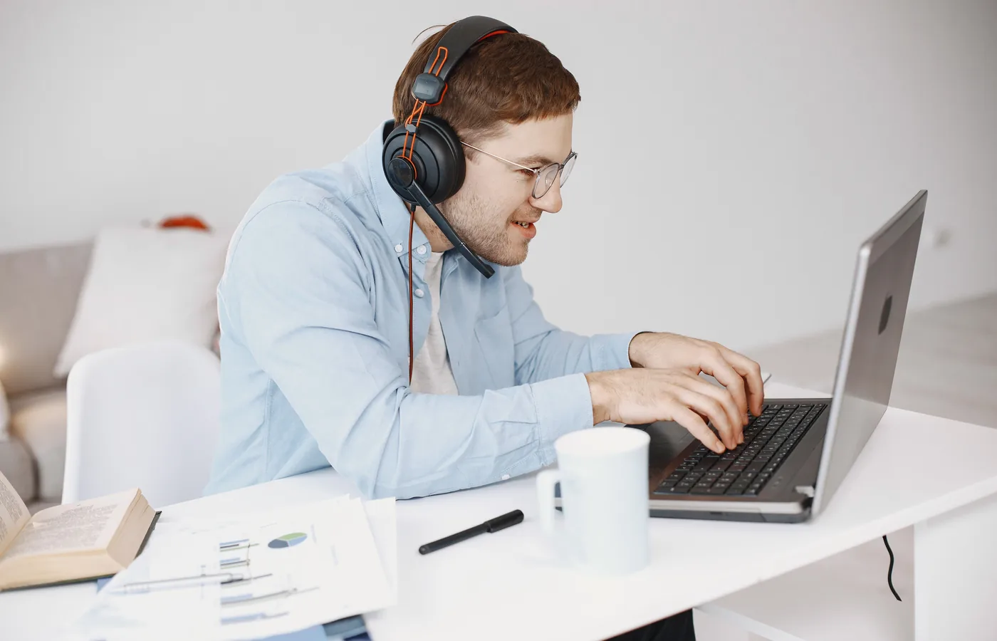 Мужчина использует ноутбук и гарнитуру для удалённой работы