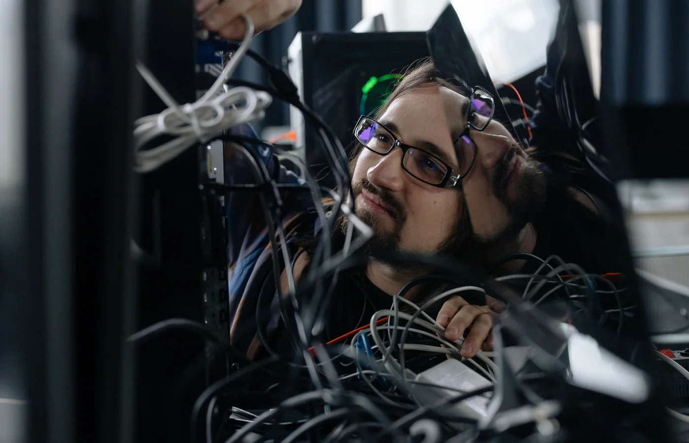 IT-специалист проверяет кабели и компьютерное оборудование в офисе
